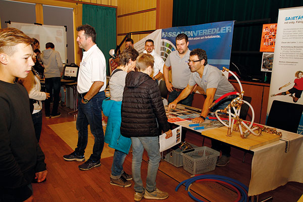 Interessierte Jugendliche und ihre Eltern unterhalten sich mit Lehrmeistern und Lehrlingen der anwesenden Flawiler Lehrbetriebe. (Bild ak)